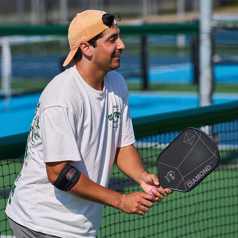Lifestyle Image of Pickleball Player wearing McDavid Elbow Strap with Pads